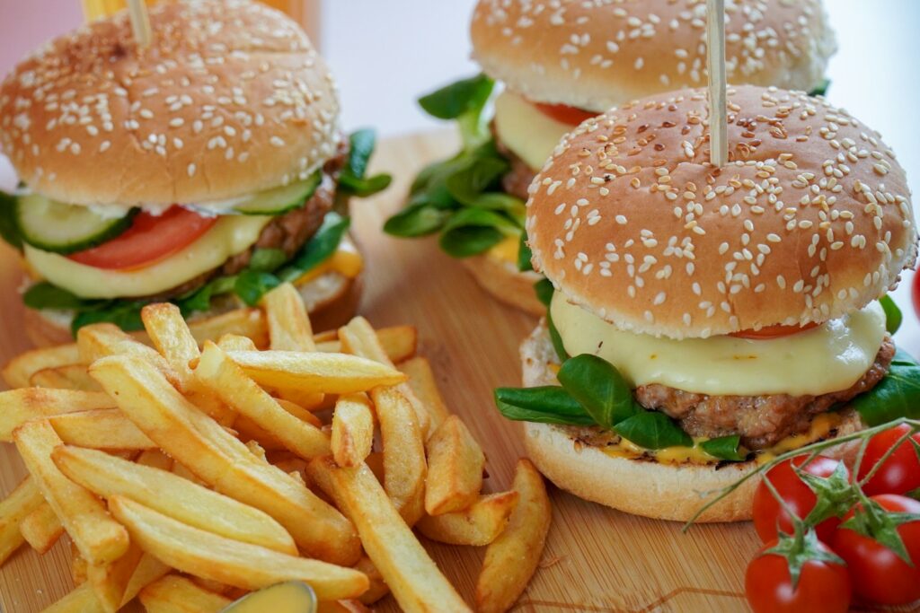 burger with lettuce and fries on brown wooden table