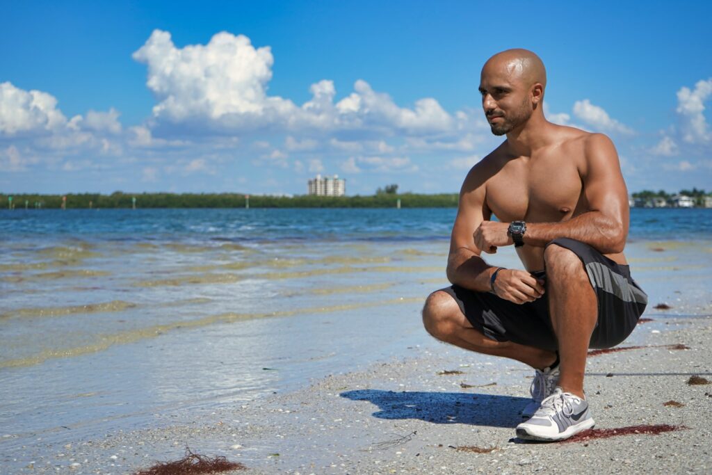 man sitting down beside seashore