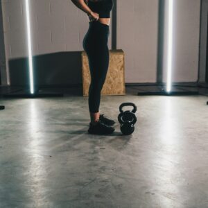 woman in black tank top and black leggings standing on white floor