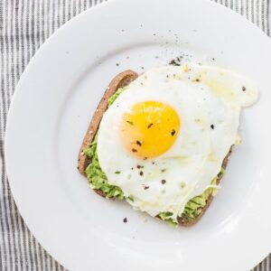 sunny side up egg, lettuce, bread on white ceramic plate
