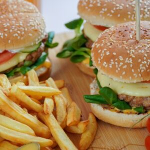 burger with lettuce and fries on brown wooden table