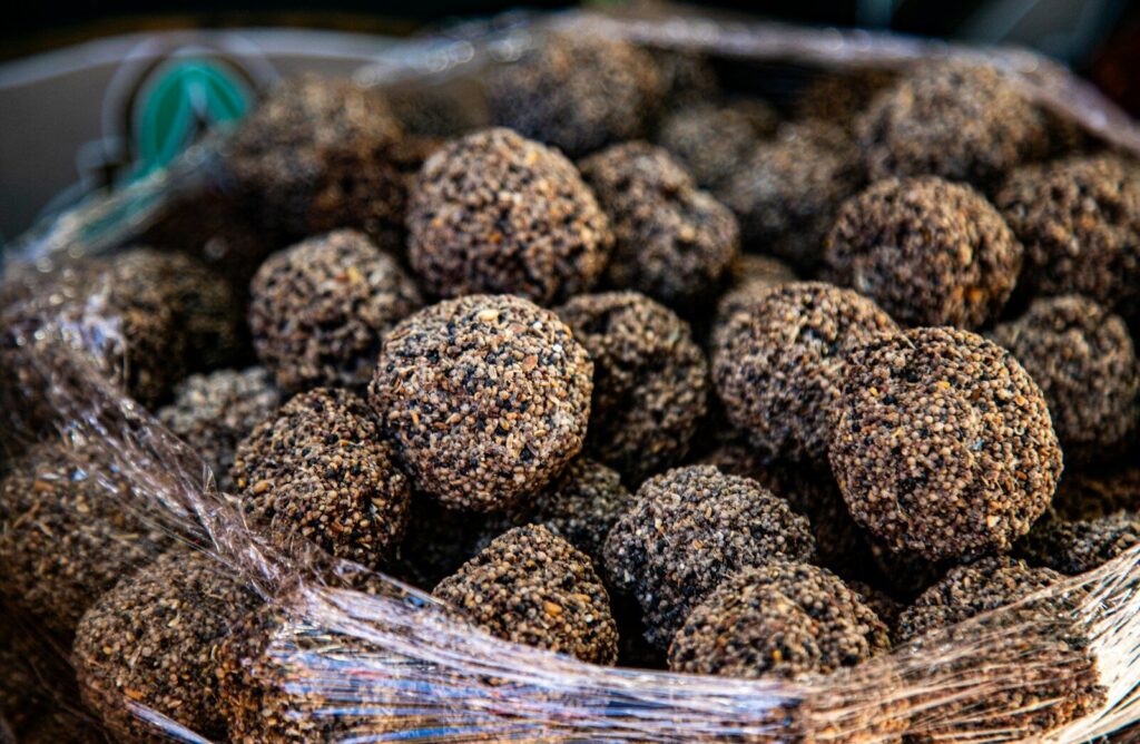 A close-up of many small, round, dark truffles.